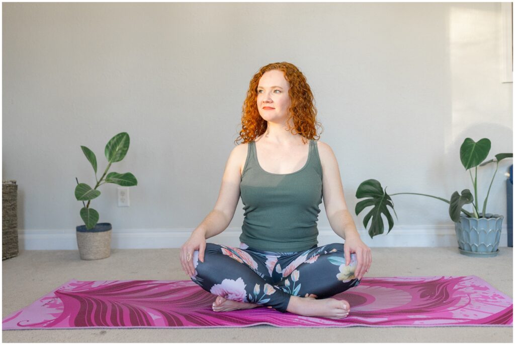 Image from branding photoshoot for Bethany Collins Consulting shows a girl with red curly hair cross legged on a yoga mat.
