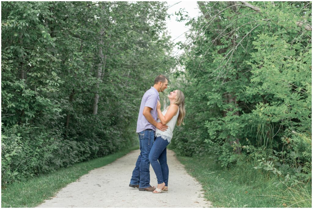 Couple laughing together on a path for their lion's den gorge engagement session.